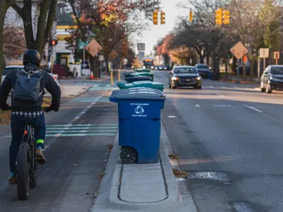 Photo of two-way bike lane with raised buffer; carts go on buffer. 
