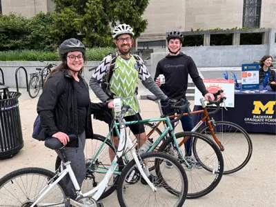 Three people showing off their bikes during Ann Arbors Bike to Wherever Day 2024
