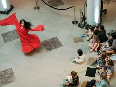 Dragons Everywhere all at once 2025 Golden Paintbrush award winning project image (person in red dress spinning while people watch)