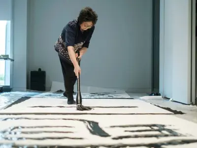 Dragons Everywhere All at Once  2025 Golden Paintbrush award winning project image (person working on painting art for the event)