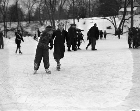 Black and white photo of two children ice skating